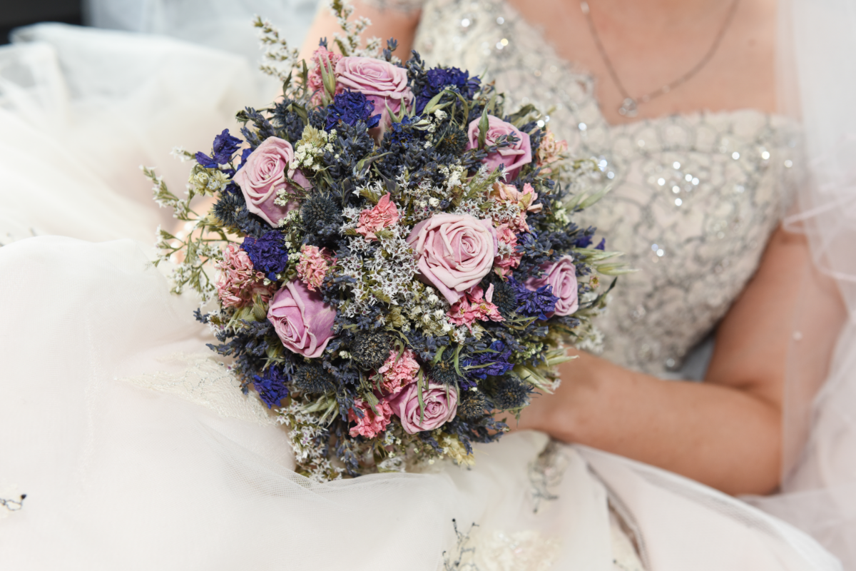 rustic bouquet with pale pink roses held by a bride with a sparkly lace corset dress